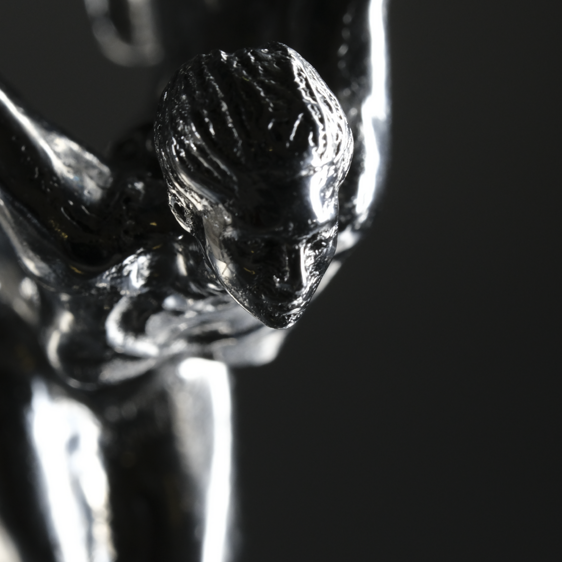 Picture of a 3D printed and then post processed female figure, high polish. The figure strongly resembles "Spirit of Ecstasy", a figurine on the front of Rolls Royce cars. 